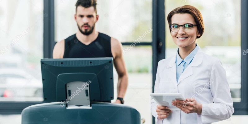 depositphotos_273810966-stock-photo-sportsman-running-treadmill-smiling-doctor